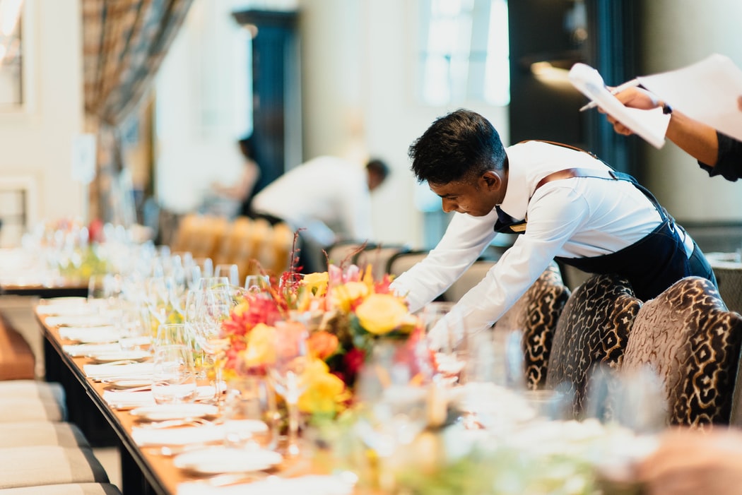 man setting the table for guests